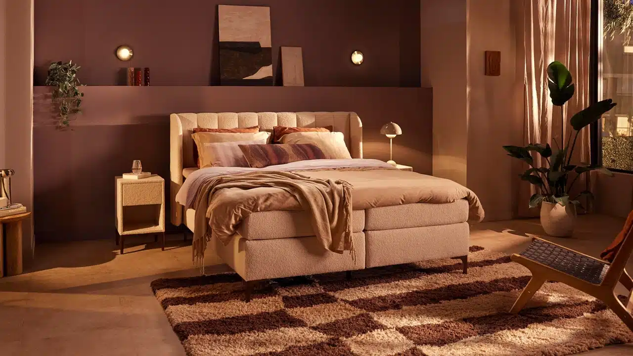 Een bed met een deken en een tapijt in een kamer